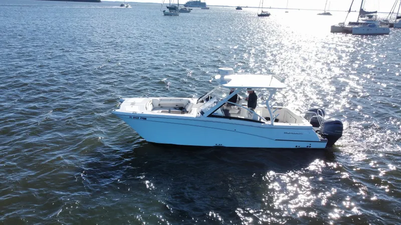 Reel'y Busy Yacht Photos Pics 2020 World Cat 280 DC x boat on sunny waters with other boats in the background.