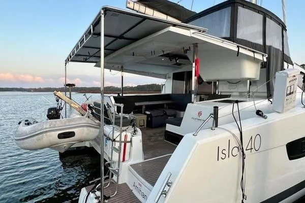 Amihan Yacht Photos Pics 2023 Fountaine Pajot Isla 40 catamaran docked, featuring spacious deck and inflatable dinghy.
