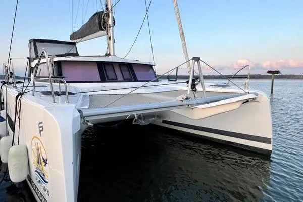 Amihan Yacht Photos Pics 2023 Fountaine Pajot Isla 40 catamaran on calm water at sunset.