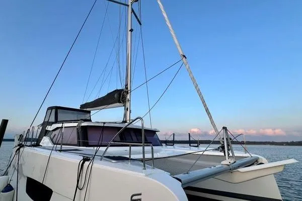 Amihan Yacht Photos Pics 2023 Fountaine Pajot Isla 40 catamaran on calm water at sunset.