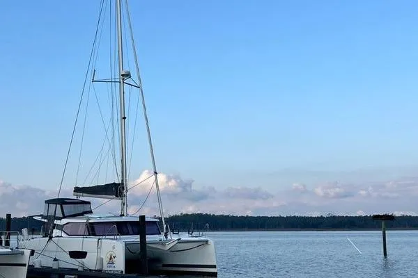 Amihan Yacht Photos Pics 2023 Fountaine Pajot Isla 40 catamaran docked on calm water under a clear blue sky.
