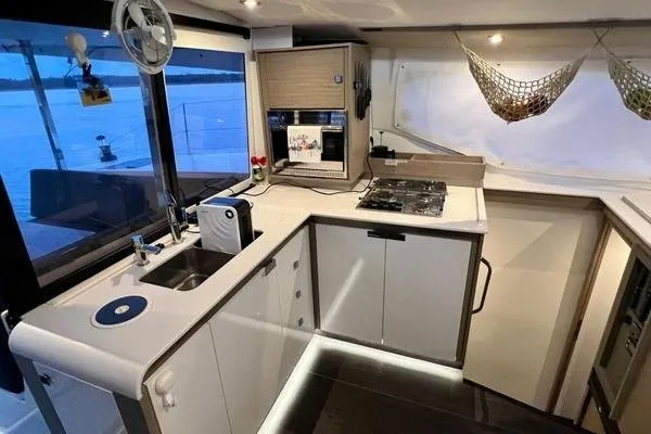 Amihan Yacht Photos Pics Modern kitchen interior of 2023 Fountaine Pajot Isla 40 catamaran with sleek design and appliances.