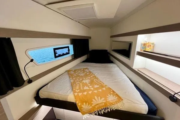 Amihan Yacht Photos Pics 2023 Fountaine Pajot Isla 40 cabin interior with bed, window, and decorative accents.