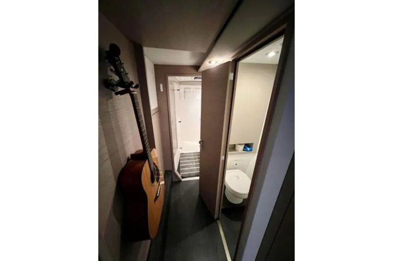 Amihan Yacht Photos Pics Interior of 2023 Fountaine Pajot Isla 40 yacht with guitar and bathroom.