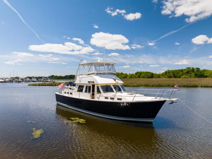 Nellie Yacht Photos Pics 1998 Sabreline 47 Aft Cabin Trawler on calm water under a clear blue sky.