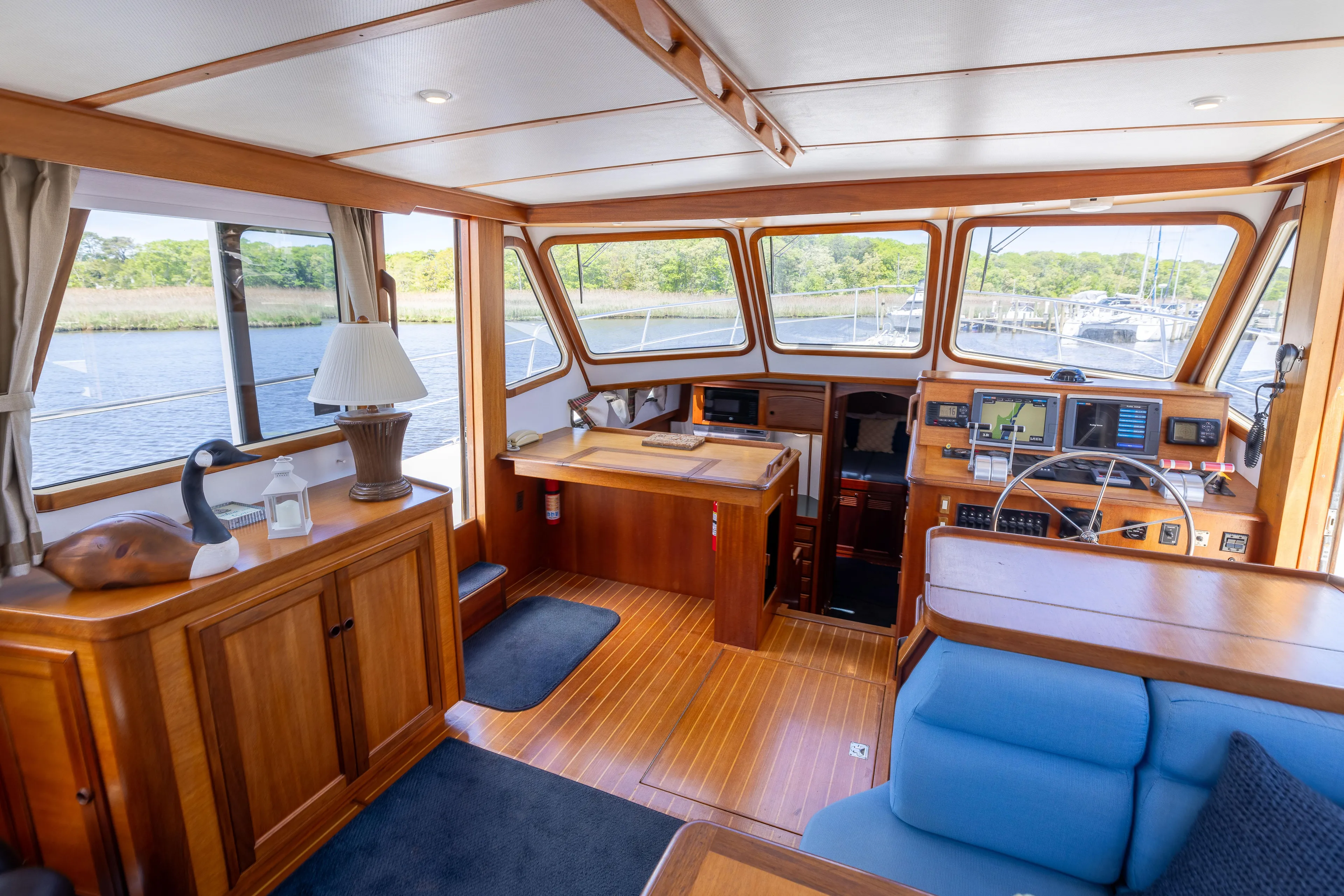 Nellie Yacht Photos Pics Interior of 1998 Sabreline 47 Aft Cabin Trawler with wooden finishes and blue seating.