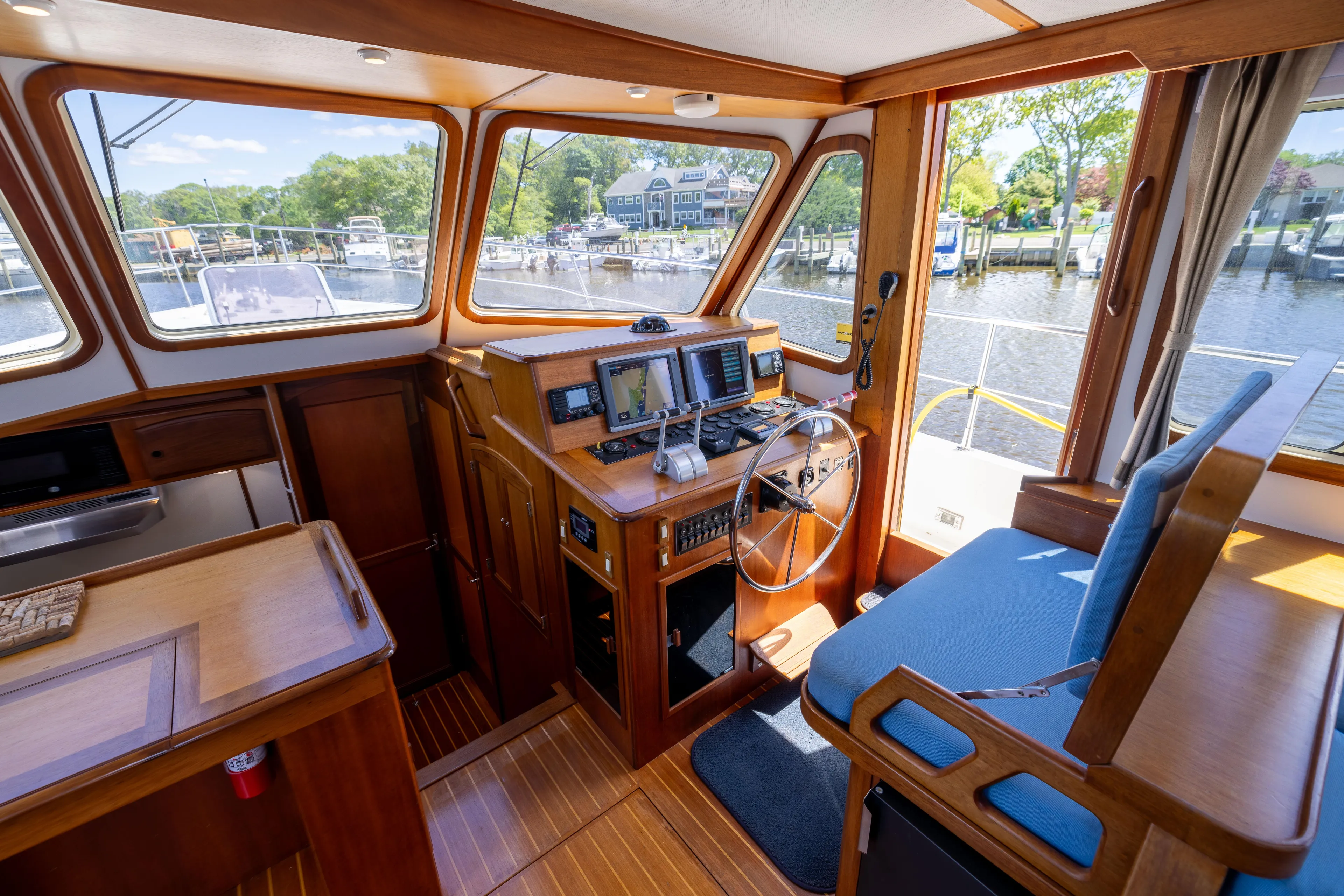 Nellie Yacht Photos Pics 1998 Sabreline 47 Aft Cabin Trawler helm with navigation equipment and waterfront view.