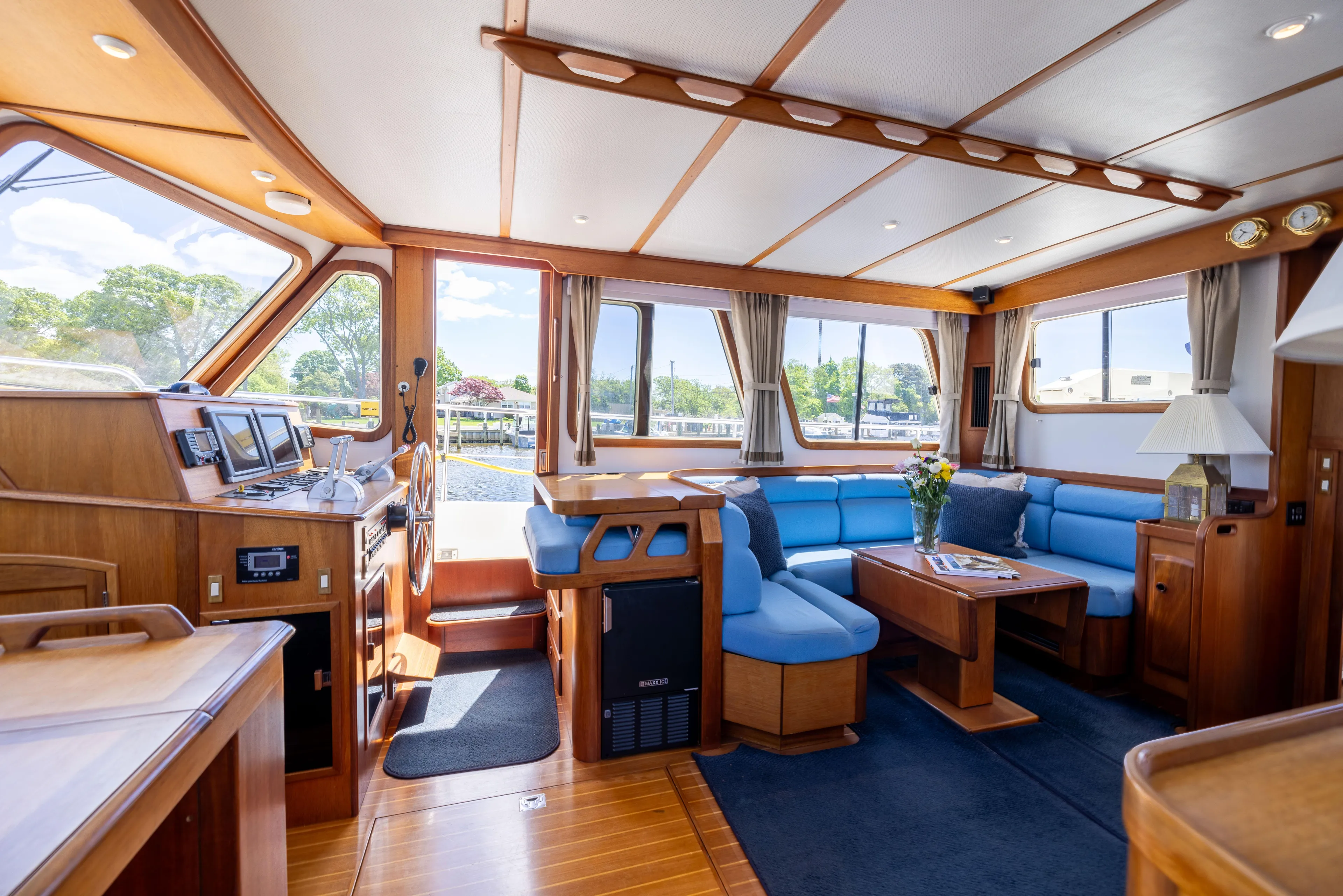 Nellie Yacht Photos Pics Interior of 1998 Sabreline 47 Aft Cabin Trawler with blue seating and wooden accents.