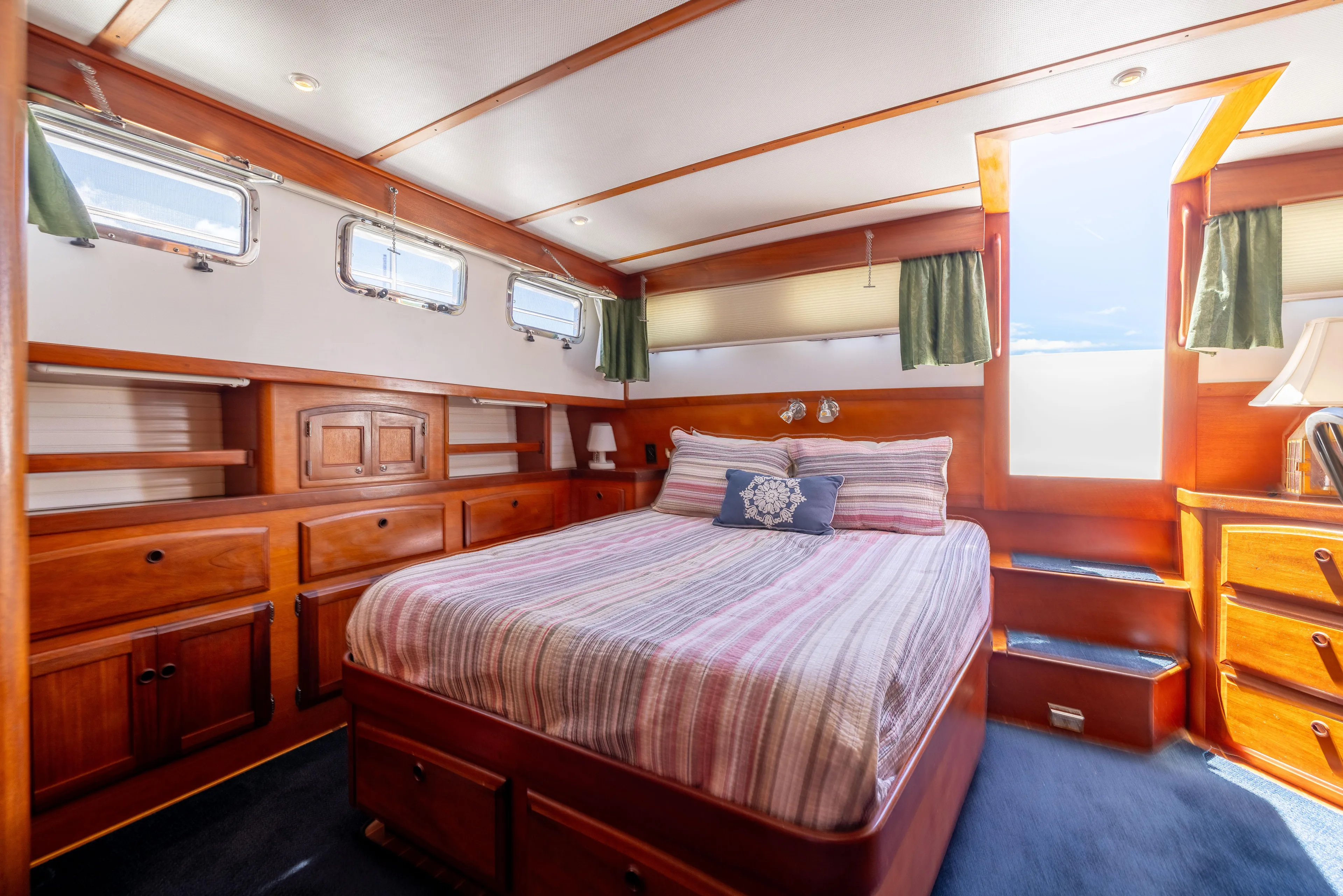 Nellie Yacht Photos Pics Luxurious 1998 Sabreline 47 Aft Cabin Trawler bedroom with wood accents and natural light.
