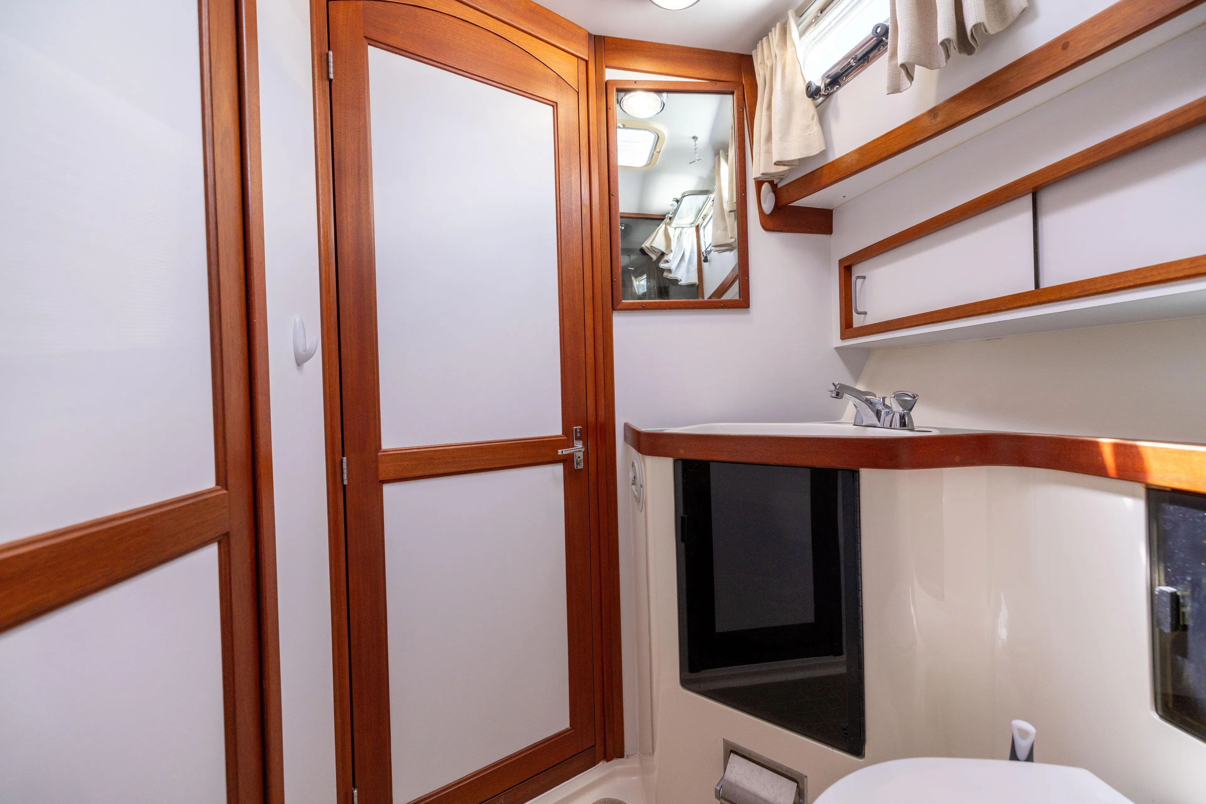 Nellie Yacht Photos Pics 1998 Sabreline 47 Aft Cabin Trawler bathroom with wood accents and modern fixtures.