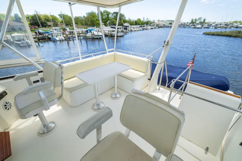 Nellie Yacht Photos Pics 1998 Sabreline 47 Aft Cabin Trawler's spacious deck with seating and table, docked by a marina.