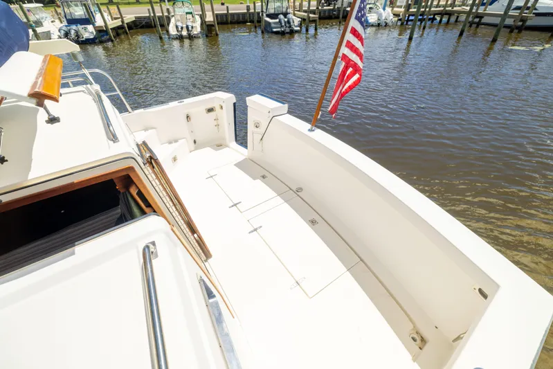 Nellie Yacht Photos Pics 1998 Sabreline 47 Aft Cabin Trawler deck with American flag, docked at marina.