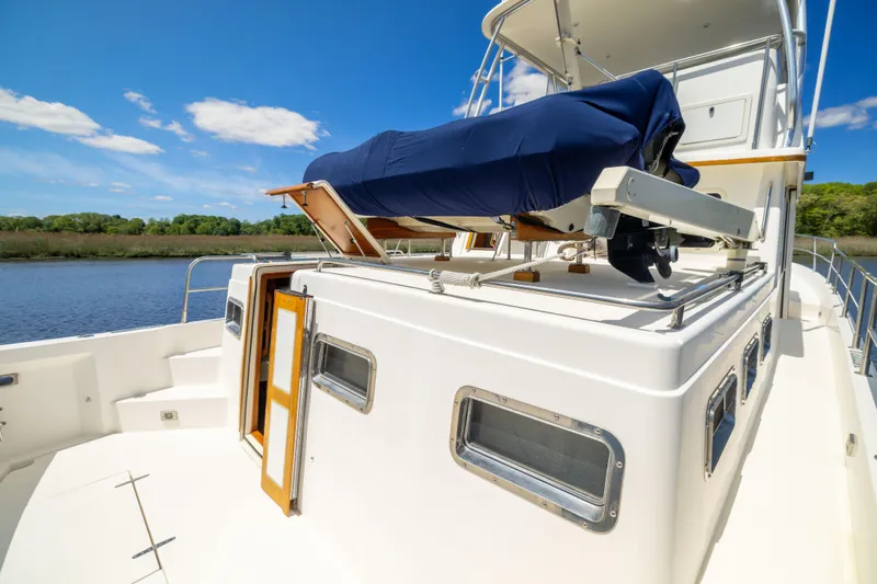 Nellie Yacht Photos Pics 1998 Sabreline 47 Aft Cabin Trawler on water, featuring upper deck and clear blue sky.