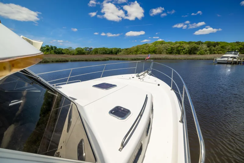 Nellie Yacht Photos Pics Sabreline 47 Aft Cabin Trawler, 1998, cruising on a serene river under a clear blue sky.