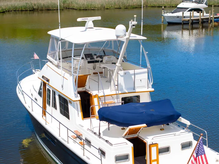 Nellie Yacht Photos Pics 1998 Sabreline 47 Aft Cabin Trawler docked on calm water, featuring spacious deck and flybridge.