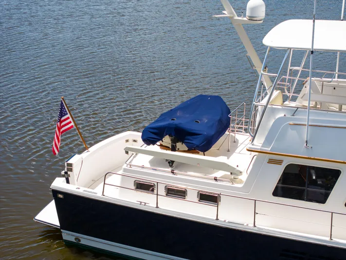 Nellie Yacht Photos Pics Sabreline 47 Aft Cabin Trawler, 1998, docked with American flag, blue cover on deck.
