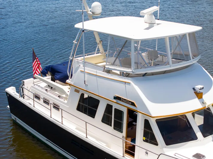Nellie Yacht Photos Pics 1998 Sabreline 47 Aft Cabin Trawler on water, featuring spacious deck and American flag.