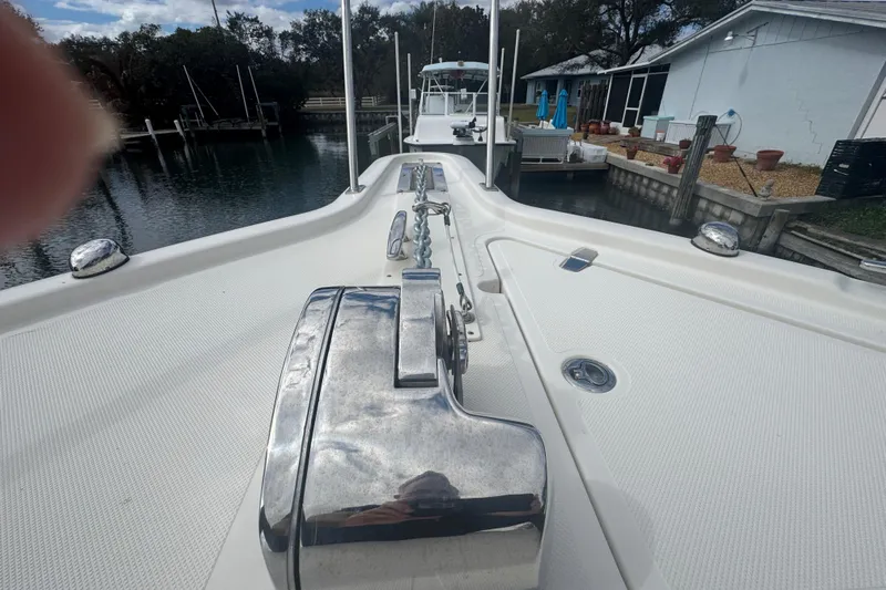  Yacht Photos Pics 2014 Pursuit OS 345 Offshore boat deck with anchor, docked near a waterfront home.