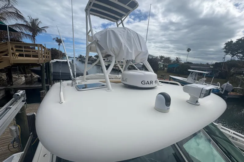  Yacht Photos Pics 2014 Pursuit OS 345 Offshore boat with radar and navigation equipment docked by palm trees.