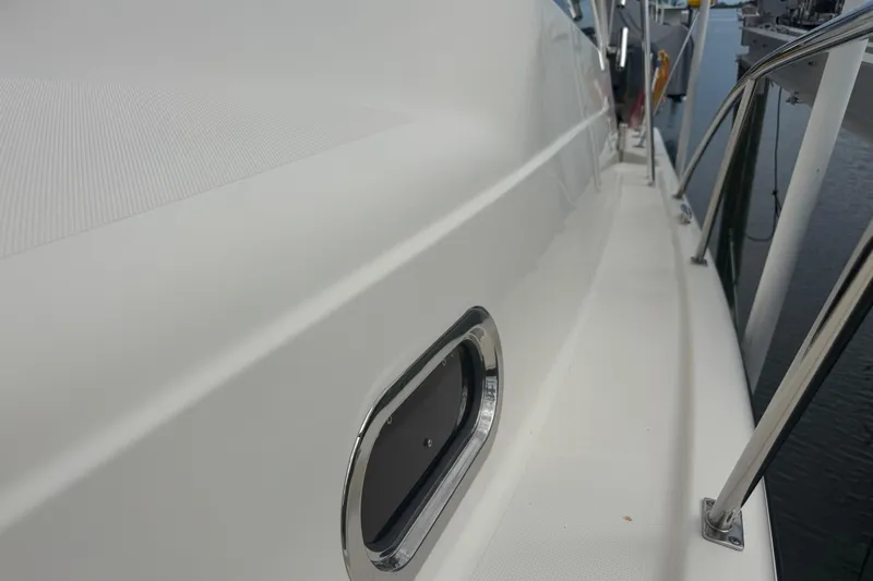  Yacht Photos Pics 2014 Pursuit OS 345 Offshore boat deck with stainless steel railing and porthole.