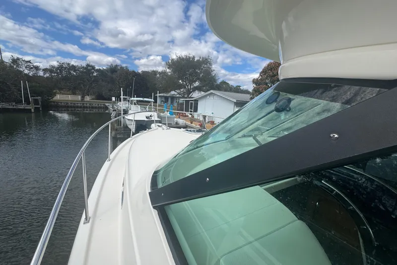  Yacht Photos Pics 2014 Pursuit OS 345 Offshore boat docked by a serene waterfront.