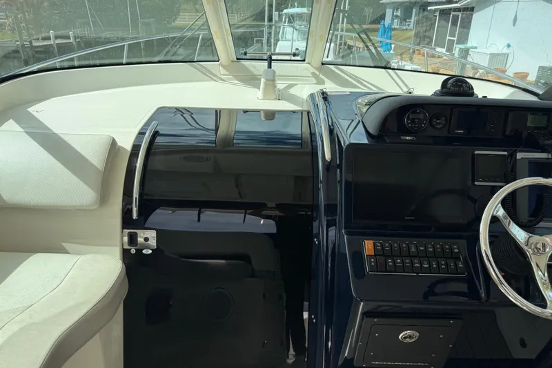  Yacht Photos Pics 2014 Pursuit OS 345 Offshore boat cockpit with steering wheel and navigation controls.