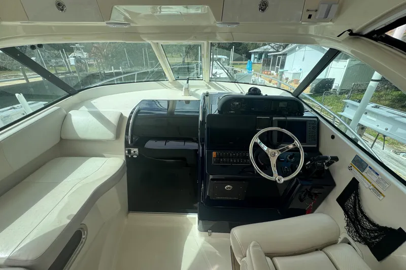  Yacht Photos Pics 2014 Pursuit OS 345 Offshore boat interior with steering wheel and seating area.