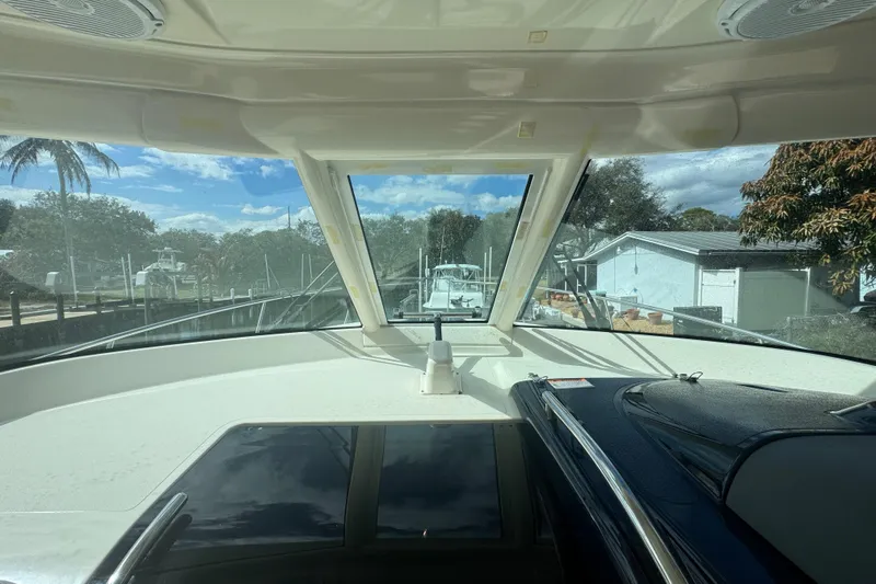  Yacht Photos Pics Interior view of 2014 Pursuit OS 345 Offshore boat with clear windshield and sunny sky.