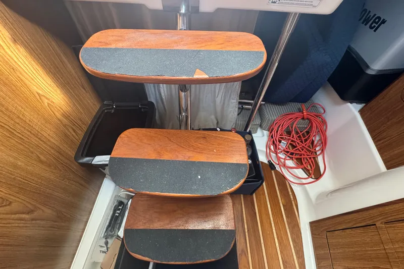  Yacht Photos Pics Wooden steps inside a 2014 Pursuit OS 345 Offshore boat, with coiled red rope nearby.