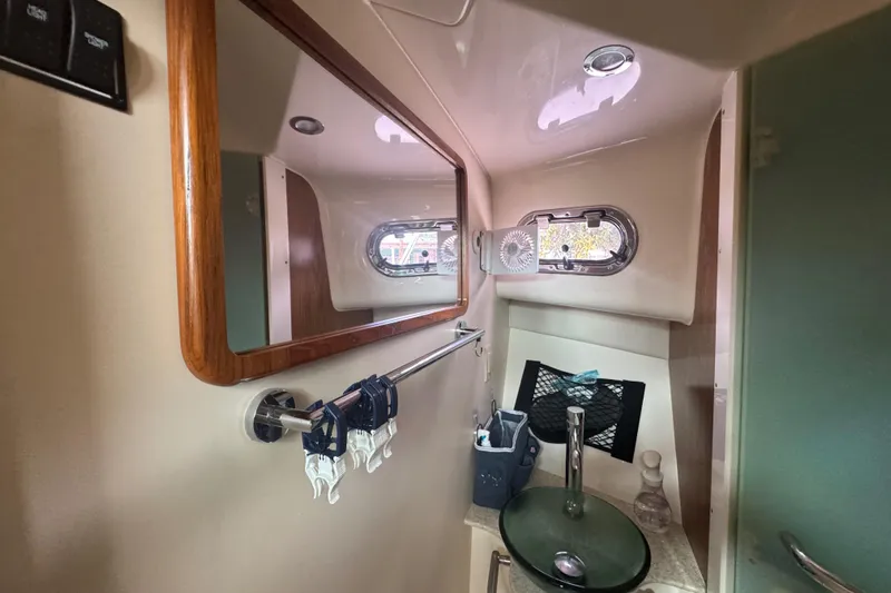  Yacht Photos Pics 2014 Pursuit OS 345 Offshore boat bathroom with mirror, sink, and porthole window.