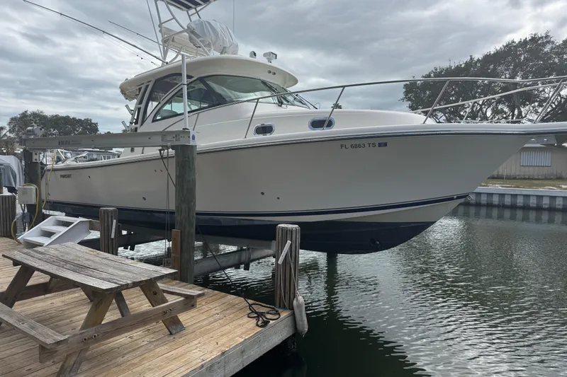  Yacht Photos Pics 2014 Pursuit OS 345 Offshore boat docked at marina with wooden picnic table nearby.