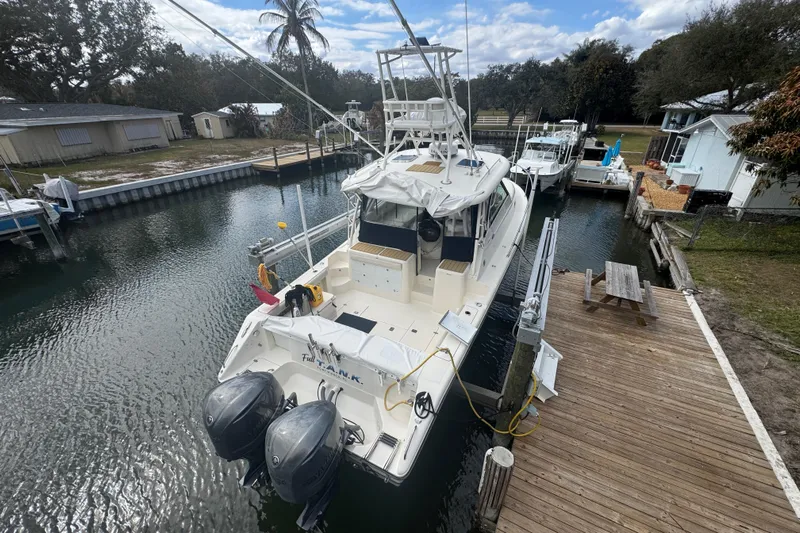  Yacht Photos Pics 2014 Pursuit OS 345 Offshore boat docked, featuring dual outboard motors and spacious deck.