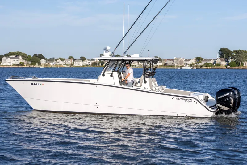  Yacht Photos Pics 2020 Freeman 34VH boat cruising on a calm lake with houses in the background.