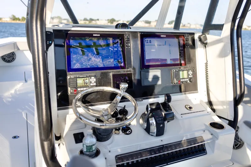  Yacht Photos Pics Control panel of a 2020 Freeman 34VH boat with navigation screens and steering wheel.