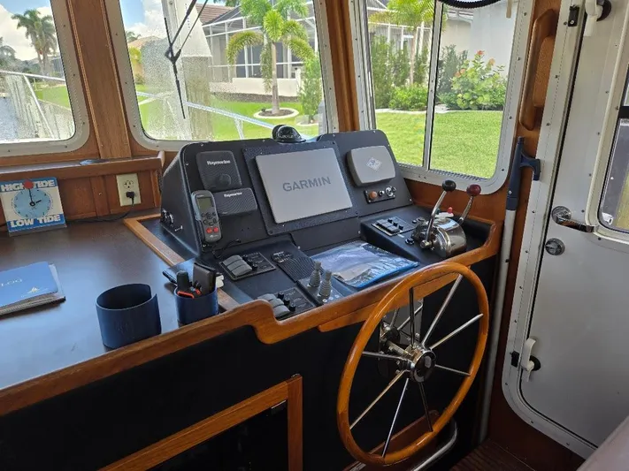 Ecola Yacht Photos Pics Pilothouse of 2005 American Tug 34 with Garmin navigation system and wooden steering wheel.