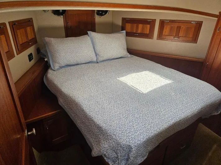 Ecola Yacht Photos Pics Cozy cabin interior of 2005 American Tug 34 Pilothouse with wooden accents and comfortable bedding.