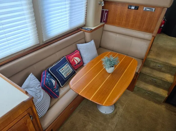Ecola Yacht Photos Pics 2005 American Tug 34 Pilothouse interior with cozy seating, nautical pillows, and wooden table.