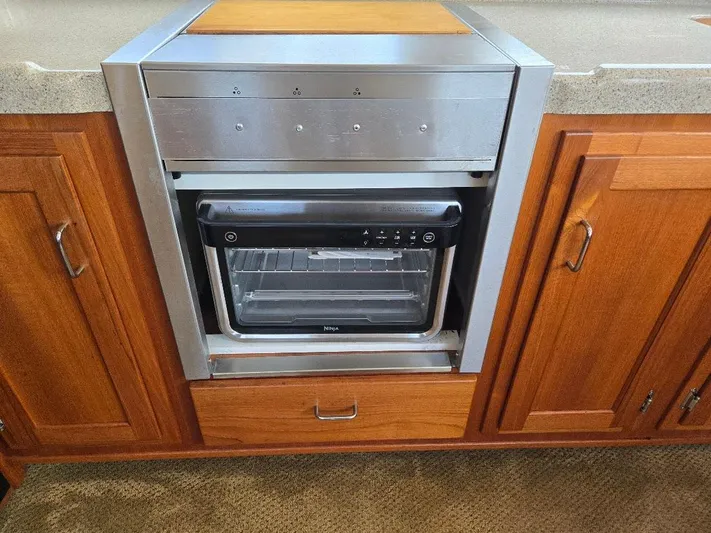 Ecola Yacht Photos Pics Built-in oven in 2005 American Tug 34 Pilothouse kitchen, surrounded by wooden cabinetry.