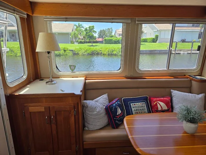 Ecola Yacht Photos Pics Cozy interior of 2005 American Tug 34 Pilothouse with cushions and table by large windows.
