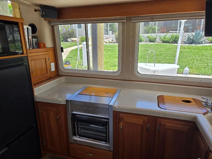 Ecola Yacht Photos Pics 2005 American Tug 34 Pilothouse kitchen with wooden cabinets, countertop, and large windows.