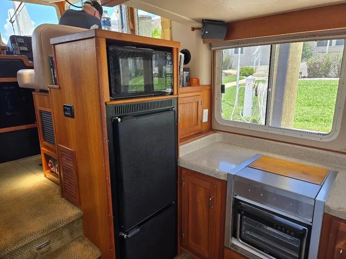 Ecola Yacht Photos Pics 2005 American Tug 34 Pilothouse interior with kitchen appliances and wooden cabinetry.