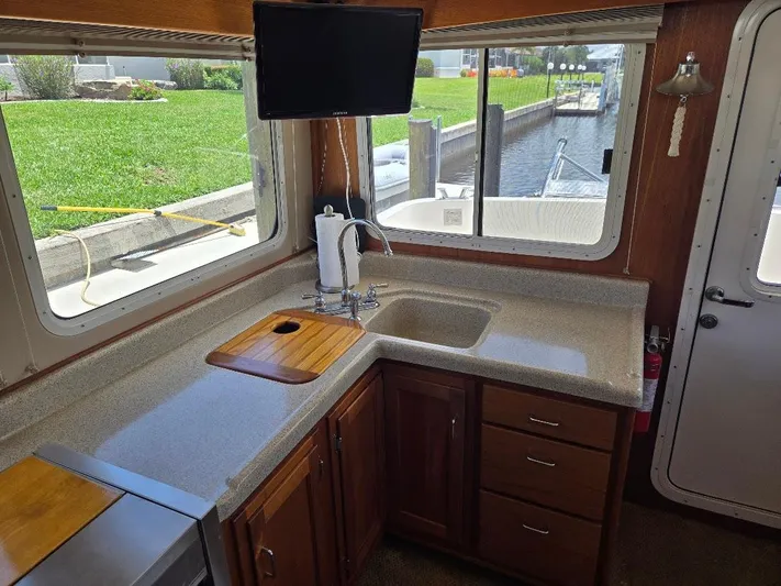 Ecola Yacht Photos Pics 2005 American Tug 34 Pilothouse interior kitchen with sink, countertop, and window view.