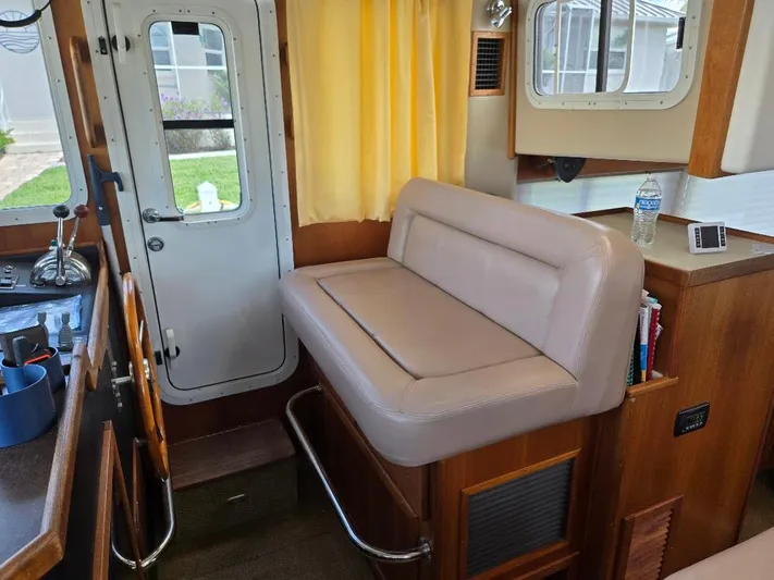 Ecola Yacht Photos Pics 2005 American Tug 34 Pilothouse interior with beige seating, wooden accents, and nautical decor.