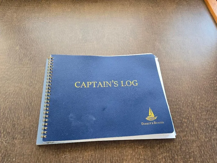 Ecola Yacht Photos Pics Blue Captain's Log book on a wooden table, American Tug 34 Pilothouse 2005.