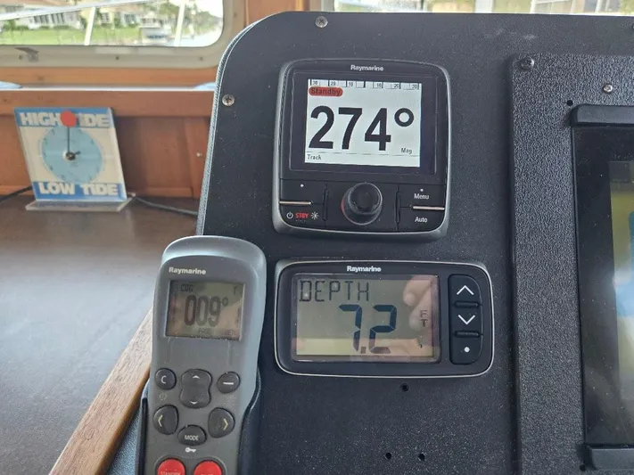Ecola Yacht Photos Pics Pilothouse instruments on a 2005 American Tug 34, showing compass, depth, and tide indicators.
