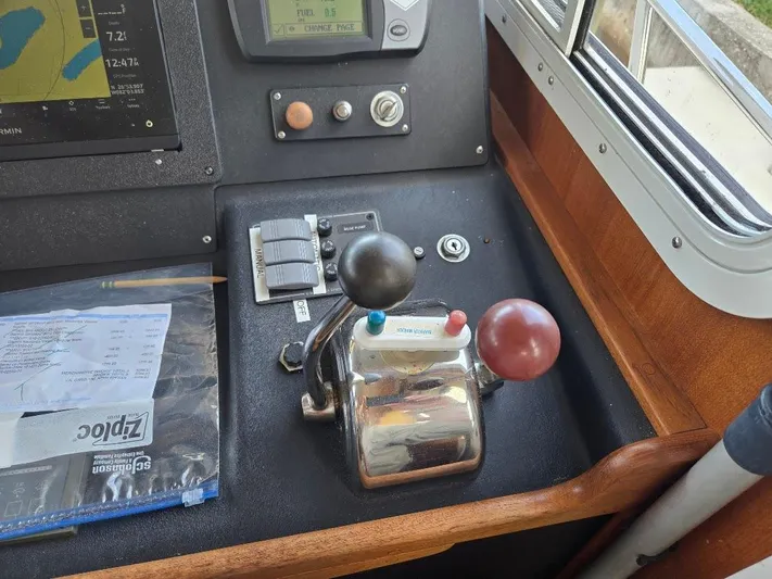 Ecola Yacht Photos Pics Control panel of a 2005 American Tug 34 Pilothouse with navigation equipment and throttle levers.
