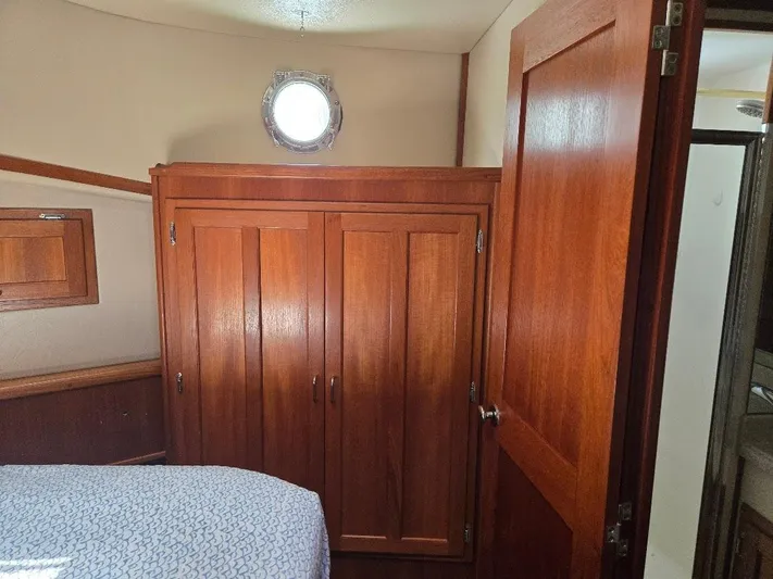 Ecola Yacht Photos Pics Interior of 2005 American Tug 34 Pilothouse with wooden cabinetry and porthole window.