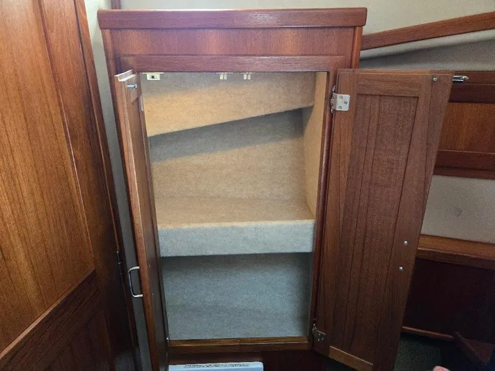 Ecola Yacht Photos Pics Open wooden cabinet with shelves inside American Tug 34 Pilothouse, 2005 model.