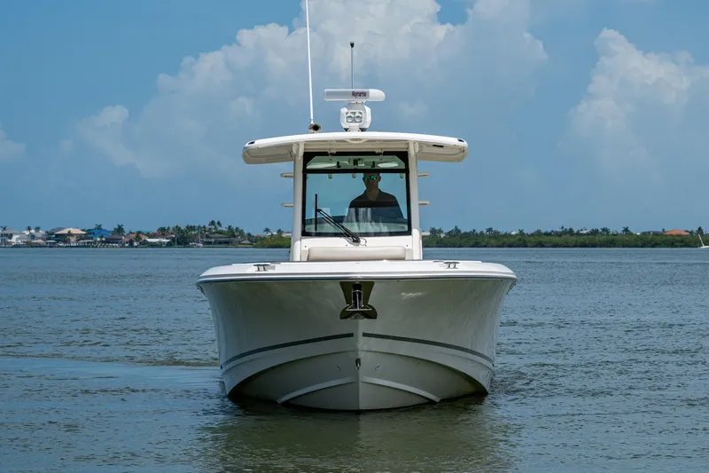 Ducky's Dinghy Yacht Photos Pics 2020 Boston Whaler 330 Outrage boat on calm water under blue sky.