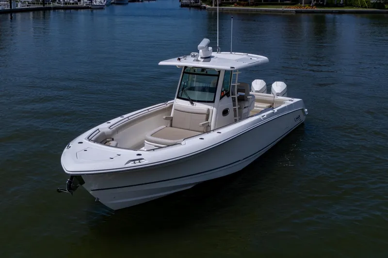Ducky's Dinghy Yacht Photos Pics 2020 Boston Whaler 330 Outrage boat on calm water, showcasing sleek design and twin engines.